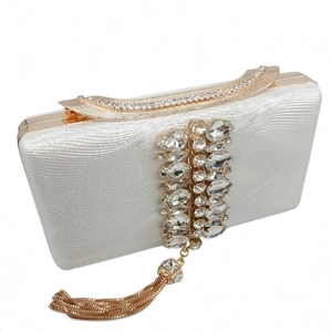 Detailed view of rhinestone clutch with elegant gold chain tassels and metallic fabric