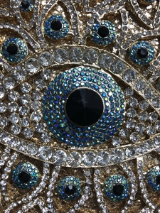 Nahaufnahme der Evil-Eye-Kristallmuster auf einer Luxus-Abendtasche mit Goldmetall
