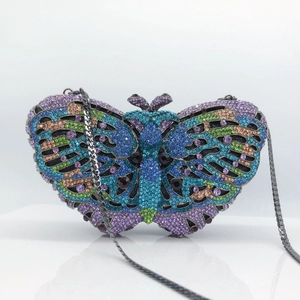 Detailed view of butterfly evening bag with vibrant crystals and silver metal chain strap