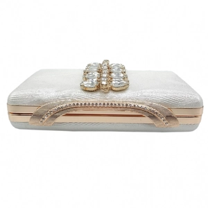 Close-up of luxury silver evening clutch with wave texture and crystal embellishment