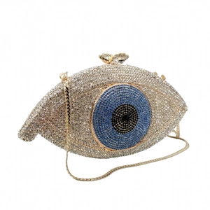 Detail of eye-shaped clutch featuring luxury rhinestones and gold butterfly clasp
