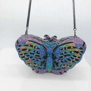 Close-up of butterfly clutch bag featuring multi-color crystals and metal chain