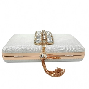 Detailed macro of silver glitter evening bag with crystal rhinestones and gold tassel