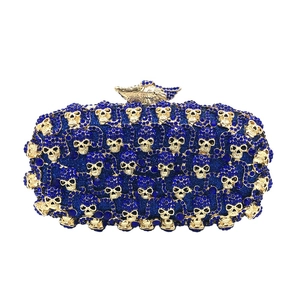 Pochette de soirée luxe en strass bleu marine avec crânes dorés et fermoir oiseau