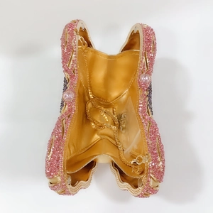 Detailed interior of pink butterfly clutch showing gold lining and detachable chain strap