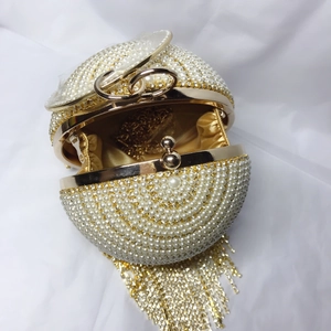 Vue détaillée du sac boule avec perles blanches, cristaux et doublure en soie dorée