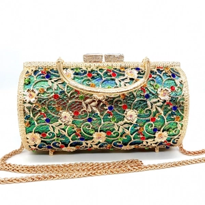 Detail of hollow metal evening clutch with colorful rhinestones and gold handle
