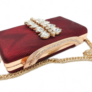 Macro detail of burgundy wave-textured fabric with sparkling crystal embellishments