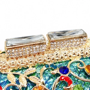 Macro shot of gold hollow metal frame clutch with colorful rhinestones and crystal clasp