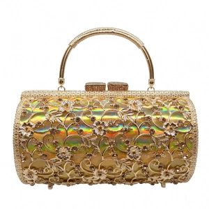 Detail of hollow metal floral engraving and sparkling rhinestones on golden evening clutch bag