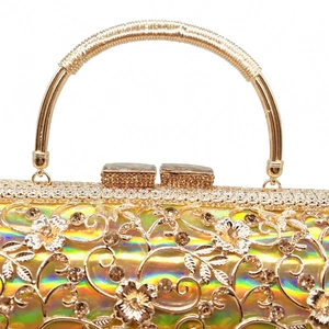Detail of gold hollow floral evening bag with iridescent finish and rhinestone clasp