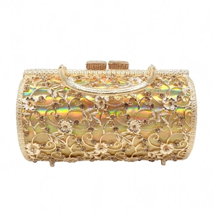 Detail of gold hollow floral evening bag with sparkling rhinestones and metal handle