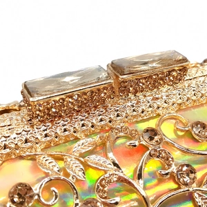 Detailed view of hollow gold metal vine pattern with crystals on luxury evening clutch bag