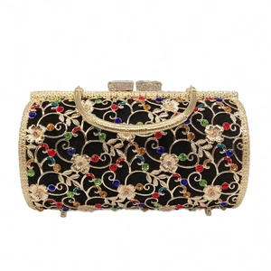Close-up of luxury hollow metal evening bag with colorful rhinestones and gold handle
