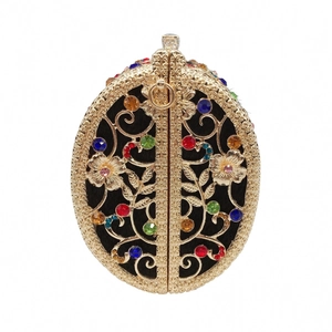 Macro shot of gold hollow-out floral patterns with colorful rhinestones on evening bag