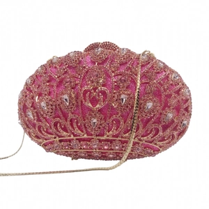 Detail of fuchsia evening clutch bag featuring rhinestone crown and heart motifs