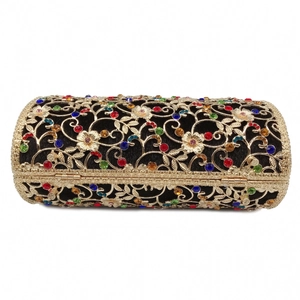 Detailed close-up of hollow gold floral metalwork and colorful rhinestones on evening bag