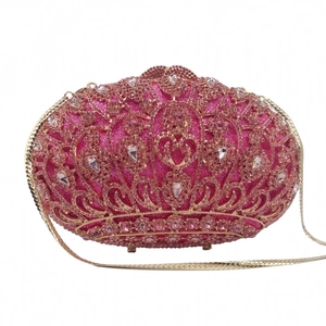 Close-up of pink crystal embellishments and golden metal chain on luxury clutch bag