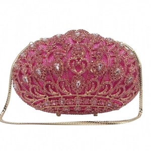 Detailed view of luxury pink crystals and gold crown-shaped filigree on the evening clutch