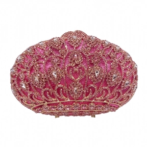 Detailed close-up of a pink sequined evening clutch with crystal heart and scroll patterns