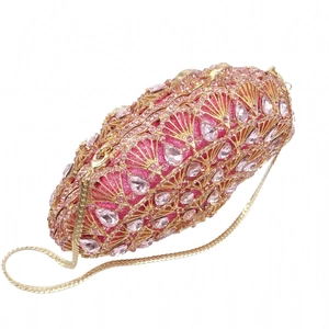Détail de la pochette de soirée en cristal rose avec motif phénix et chaîne dorée
