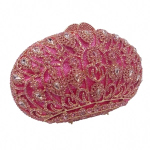 Detailed close-up of pink rhinestones and gold filigree on a luxury evening clutch bag