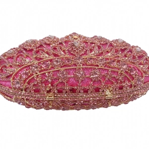 Detailed macro view of pink rhinestones and gold hollow metal frame on evening clutch bag