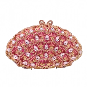 Détail de la pochette en cristal rose avec motif de paon en éventail et bord doré