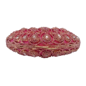 Detailed shot of pink rhinestones and teardrop crystal patterns on a luxury clutch bag
