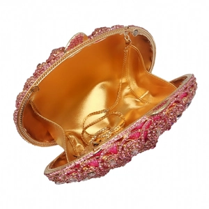 Detail of rose pink rhinestone clutch bag showing gold satin lining and chain strap