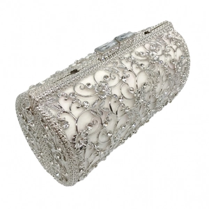 Detail of silver hollow metal clutch bag with intricate floral patterns and rhinestones