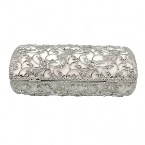 Close-up of a silver hollow metal clutch bag featuring intricate flower engravings and rhinestones