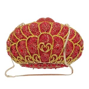 Macro view of red and yellow rhinestone patterns and gold chain on luxury clutch bag