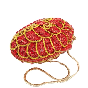 Macro detail of red rhinestone peacock feather pattern on luxury clutch bag