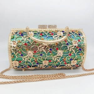 Detail of hollow floral metal frame with multicolored rhinestones on a gold evening bag