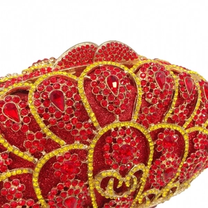 Exquisite close-up of red crystals and golden feather patterns on the luxury clutch bag