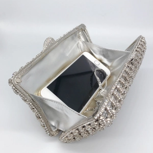 Silver rhinestone evening clutch with metal frame and chain showing interior capacity