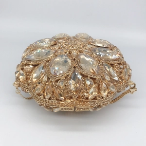 Golden hollow metal clutch bag with sparkling crystals and a fine chain strap