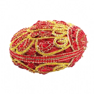 Macro detail of red and gold rhinestones on luxury oval evening clutch bag with metal frame