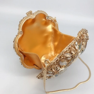 Luxurious gold evening clutch with hollow metal frame and pear-shaped crystal inlay