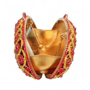 Macro view of crystal encrusted round clutch showing gold chain and internal lining