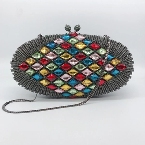 Makrodetail einer ovalen Hartschalen-Clutch besetzt mit bunten Diamantkristallen