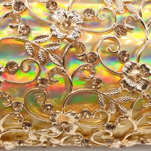 Macro detail of hollowed metal evening bag with rhinestones and holographic finish