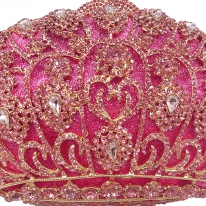 Detailed close-up of pink rhinestones and crown embellishment on luxury evening clutch bag