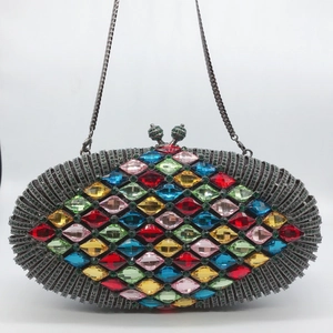 Makroaufnahme einer farbenfrohen Abendtasche mit Diamanten, Metallkette und Kristallschloss
