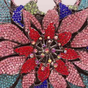 Dettaglio di pochette da sera di lusso con strass colorati e motivi floreali