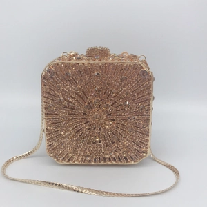 Close-up of golden evening clutch featuring radiant crystal patterns and a snake chain