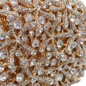 Detailed macro shot of a golden metal evening bag encrusted with sparkling crystals