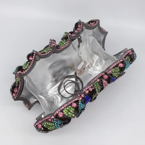 Dettaglio della lussuosa borsa da sera con strass colorati e tracolla a catena argento