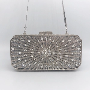 Detailed view of silver crystal evening clutch featuring a radial flower rhinestone pattern